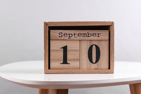 Wooden calendar organizer with date September 10 on table