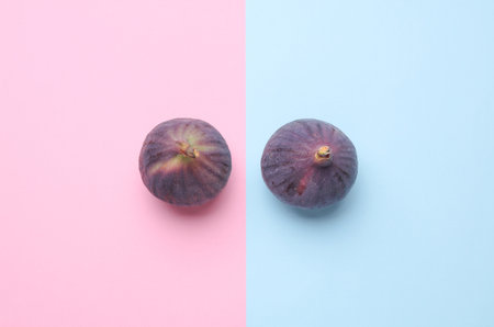 Ripe fig fruits on blue pink background. Top view