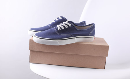 Cardboard shoe box with sneakers on a chair