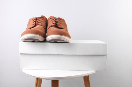 Cardboard shoe box with suede shoes on tableの写真素材