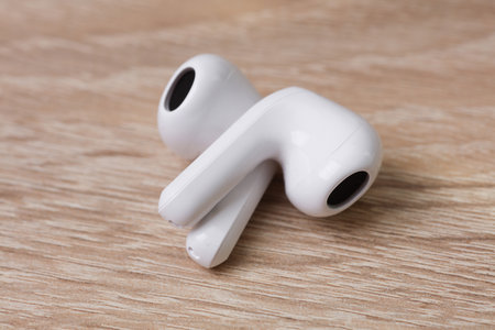 White Wireless earphones on table close up