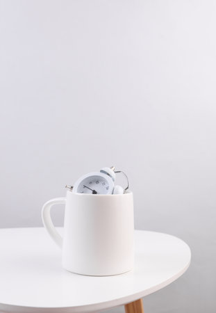 White ceramic cup with clock on table