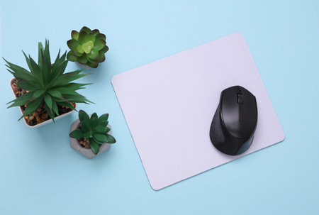 Mockup of white blank computer mouse pad with props, decorative plants on pink background. Top view....