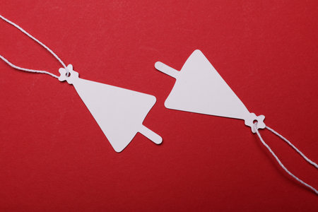 White blank tags in the shape of a Christmas tree on red background
