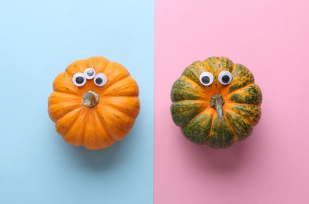 Pumpkins with googly eyes on a pink blue background. Halloween decor, handmade for holiday, 31 October. Top viewの写真素材