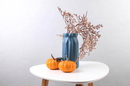 Vase with dry flower and pumpkin on the table. Autumn still lifeの写真素材