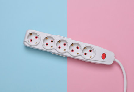 White electric extension cord with power button on blue pink backgroundの写真素材