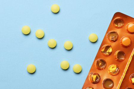 Yellow pills with orange blisters on blue background