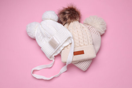 Children's warm hats with a balabons on a pink background