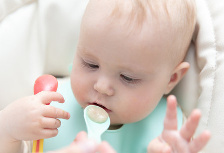 Mom feeds baby with a spoon