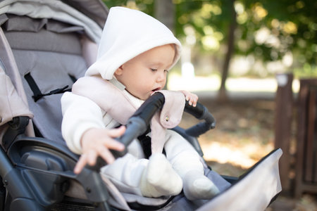 Little cute baby sitting in stroller outdoors