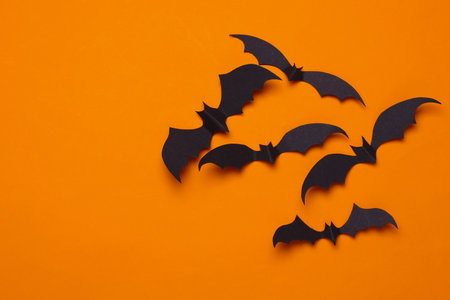 Paper cut black bats on orange background. Halloween decorの写真素材