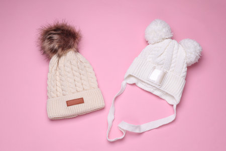 Children's warm hats with a balabons on a pink background