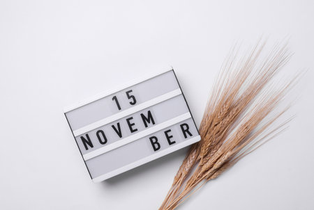November 15 letterboard text on Lightbox with dry wheat, white background. Seasonal calendar. Flat...