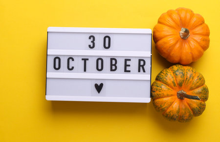 30 October letterboard text on LED Lightbox with pumpkins, yellow background. Seasonal calendar. Flat lay. Top viewの写真素材