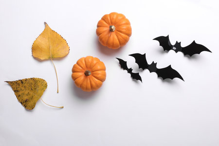Happy Halloween holiday decor. Bats, falling autumn leaves and pumpkins on white background. Flat layの写真素材