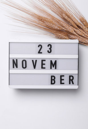 November 23 letterboard text on Lightbox with dry wheat, white background. Seasonal calendar. Flat lay. Top viewの写真素材