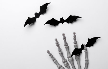 Halloween decoration concept. Plastic skeleton hands with bats on white backgroundの写真素材