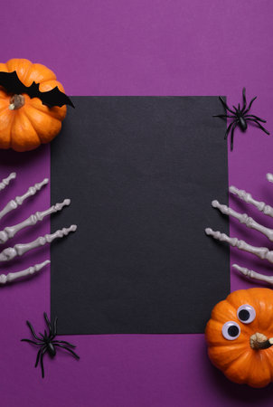 Black invitation card with Halloween decor on purple background. Flat layの写真素材
