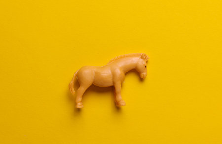 Plastic toy donkey figurine on yellow backgroundの写真素材
