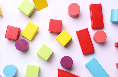 Multicolored wooden children's toy cubes of different shapes on a white backgroundの写真素材