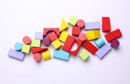 Multicolored wooden children's toy cubes of different shapes on a white background