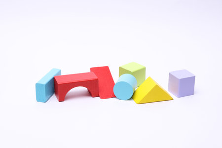 Multicolored wooden children's toy cubes of different shapes on white background