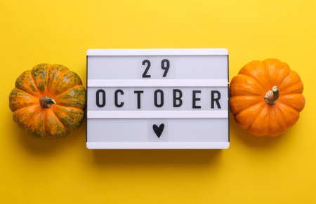 29 October letterboard text on LED Lightbox with pumpkins, yellow background. Seasonal calendar. Flat lay. Top viewの写真素材