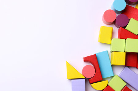 Multicolored wooden children's toy cubes of different shapes on a white background. Copy space