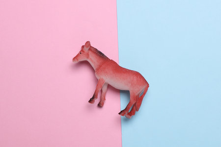 Toy plastic horse on pink blue backgroundの写真素材