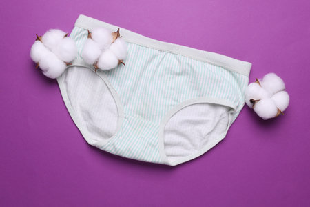 Women's comfortable panties with cotton flowers on purple background. Natural underwearの写真素材