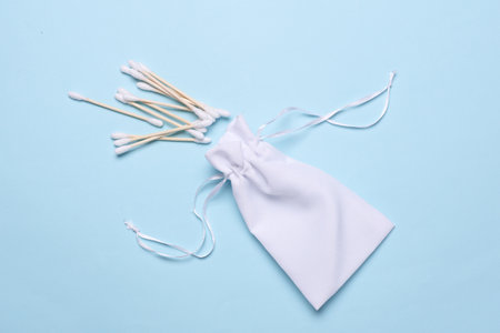 White bag with cotton swabs on blue backgroundの写真素材