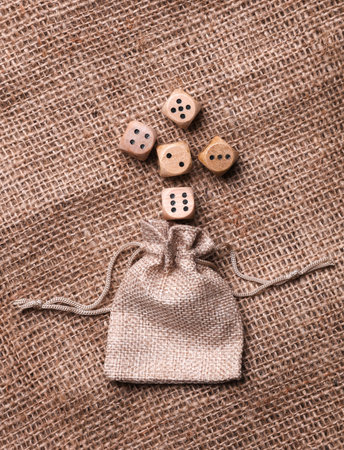 Wooden dice with a bag on burlap
