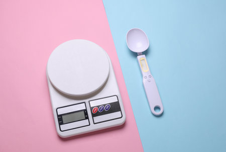 Electronic kitchen scales and smart spoon on pink blue background