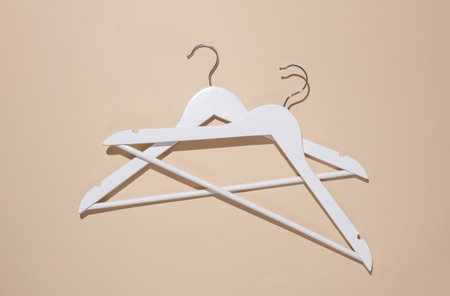 White wooden hangers on beige background. Top view. Flat layの写真素材