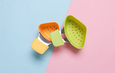 Plastic colander for a saucepan on pink blue background. Top view