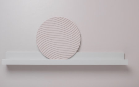 Wall shelf with round plaster figure decor on white backgroundの写真素材