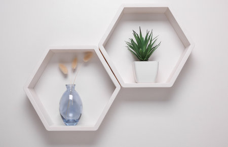 Hexagonal honeycomb shelves with decor on white background. Wall decorationの写真素材