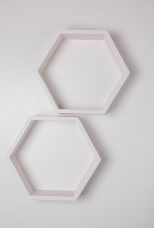 Hexagonal honeycomb shelves on white wall background