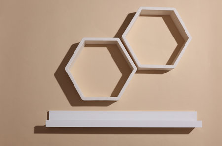 White hexagonal and straight wall shelves on beige backgroundの写真素材