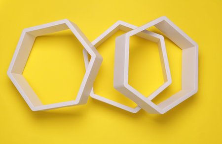Hexagonal honeycomb wall shelves on yellow background