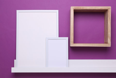 Wall Sheves with empty photo frames on purple background. Mockup for design