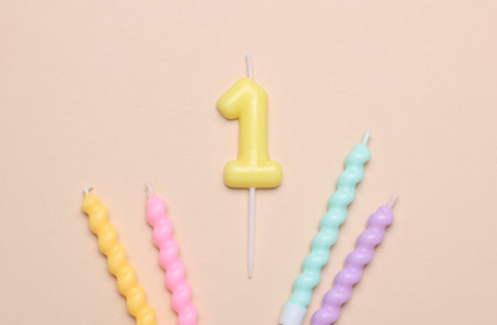 Spiral birthday candles with number 1 on beige background