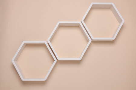Hexagonal honeycomb shelves on beige wall backgroundの写真素材