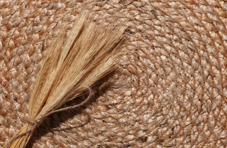 Dried ears of wheat on a woven straw mat