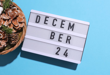 Lightbox calendar with text December 24 with Christmas, New Year winter decor on blue backgroundの写真素材