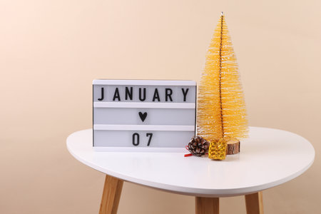 Lightbox calendar with date January 07 on table with christmas decorative tree. Holiday concept