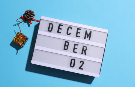 Lightbox calendar with text December 02 with Christmas, New Year winter decor on blue background