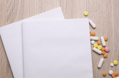 Blank medical journal or notebook with white cover and medicines on table. Mockup for designの写真素材
