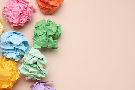 Colored balls of crumpled paper on a beige background.の写真素材